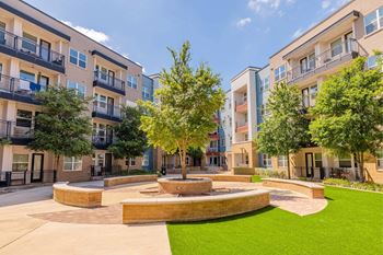 A courtyard with a fountain surrounded by apartment buildings. at Bridge at Henley, Austin, Texas